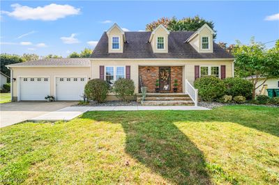 Cape cod home with a front yard and a garage | Image 1