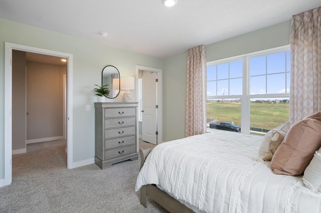 Each of the spacious secondary bedrooms feature well thought out window locations and a walk-in closet. Model photo. Options and colors will vary. | Image 25