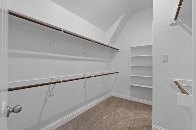Primary bedroom's walk in closet with carpet flooring. | Image 15