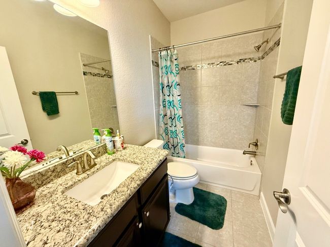 Full bathroom with vanity, tile patterned floors, toilet, and shower / bath combo | Image 31