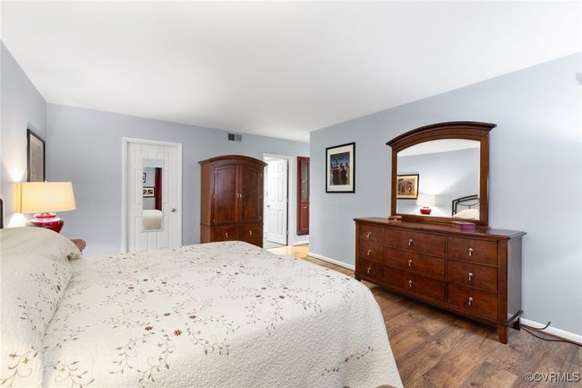 Bedroom with visible vents, wood finished floors, and baseboards | Image 18