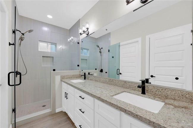 Full bathroom with double vanity, a sink, wood-style tile flooring, and a shower stall | Image 7