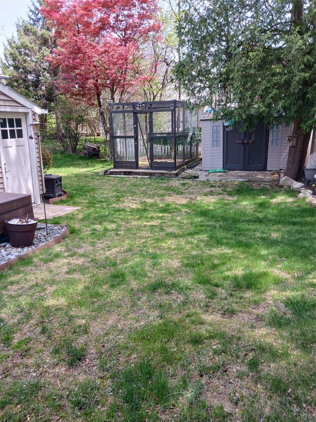 View of yard featuring a storage shed and an outbuilding | Image 5