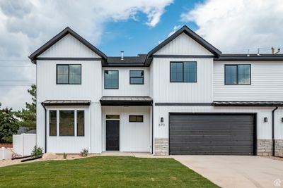 View of front of property featuring a garage and a front yard | Image 1