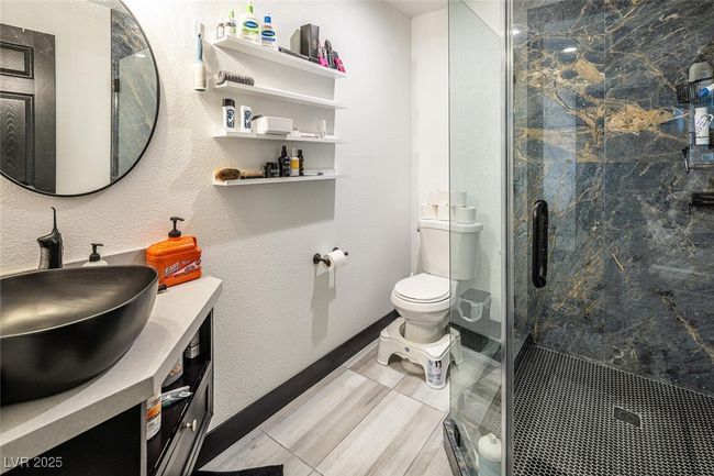 Bathroom with vanity, baseboards, a marble finish shower, toilet, and a textured wall | Image 29