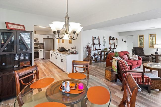 Dining space featuring light wood finished floors and a notable chandelier | Image 8