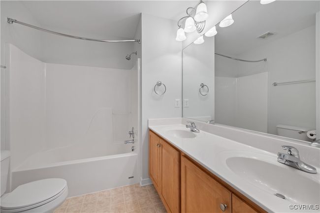 Full bathroom with visible vents, toilet, shower / tub combination, and double sinks | Image 33