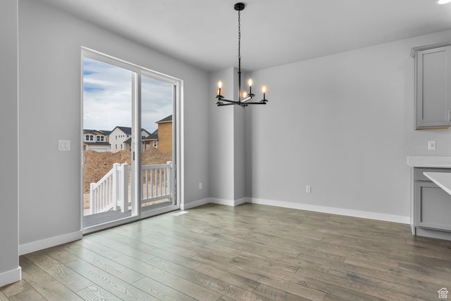 Unfurnished dining area featuring a chandelier and light wood finished floors | Image 15