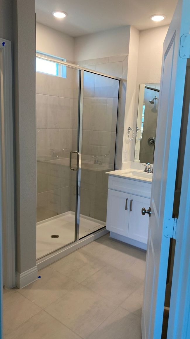 Bathroom featuring vanity, a stall shower, tile patterned flooring, and recessed lighting | Image 9