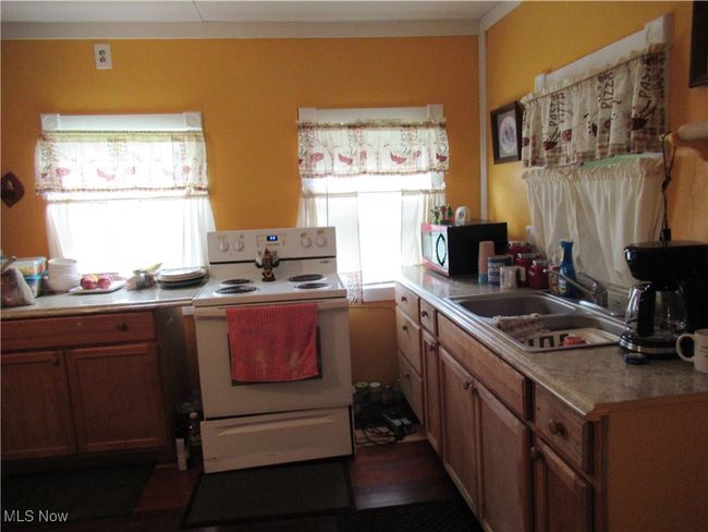 Electric stove and sink area seen here | Image 10