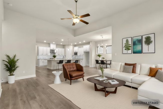 Virtually staged Living room featuring light wood finished floors, recessed lighting, a ceiling fan, a chandelier, and baseboards | Image 17