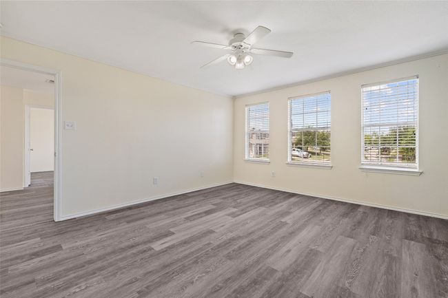 Empty room featuring wood finished floors, ceiling fan, and healthy amount of natural light | Image 7