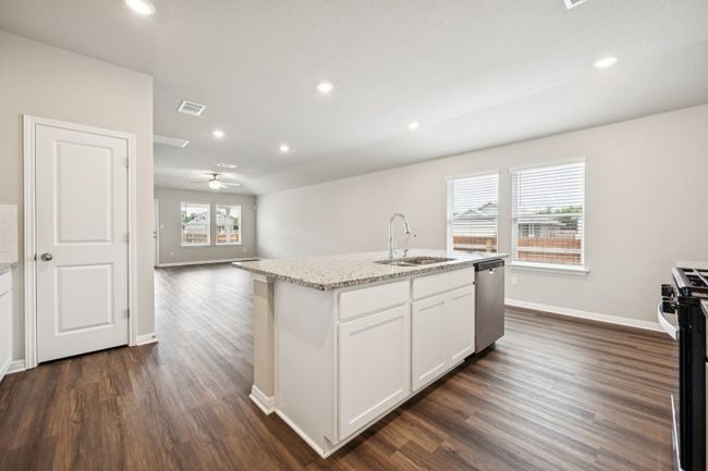 Kitchen featuring stainless steel appliances, dark wood finished floors, light stone countertops, white cabinets, and recessed lighting | Image 5