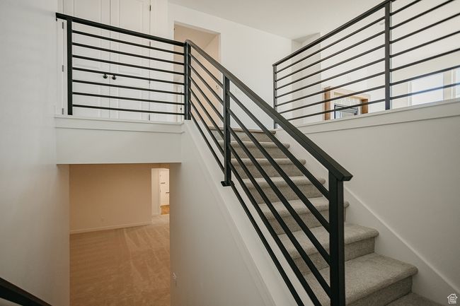 Stairs featuring a towering ceiling, carpet, and baseboards | Image 35