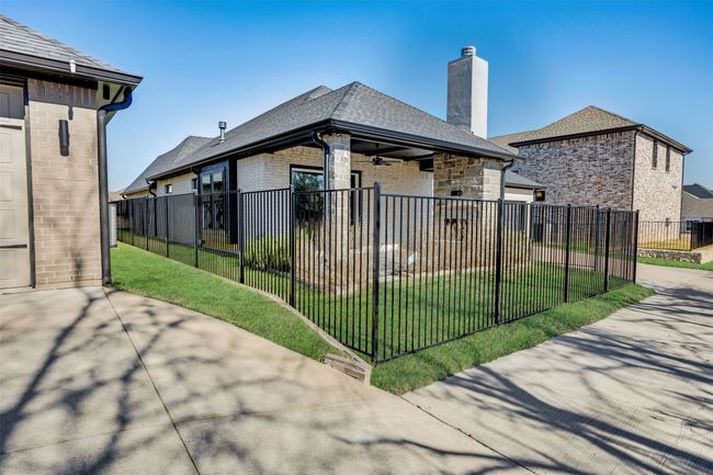 Back of property featuring a chimney, brick siding, a fenced front yard, a shingled roof, and a yard | Image 22