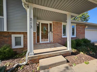 Doorway to property with a porch and a garage | Image 2