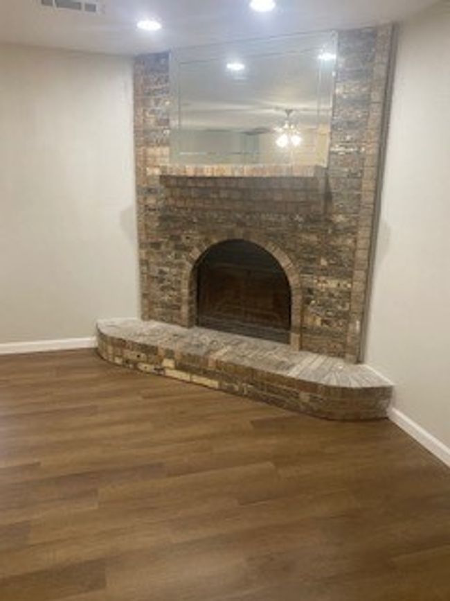 Detailed view of baseboards, recessed lighting, wood finished floors, and a fireplace | Image 7