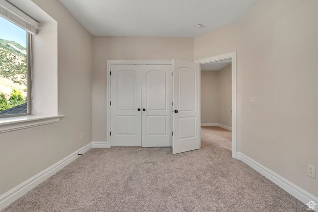 Unfurnished bedroom with carpet flooring and a closet | Image 23