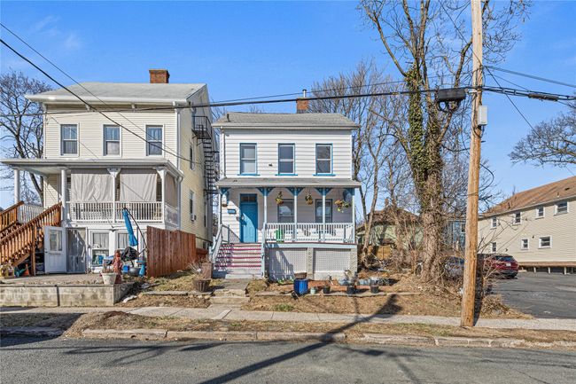 View of front of home with stairway, covered porch, a chimney, and a shingled roof | Image 28