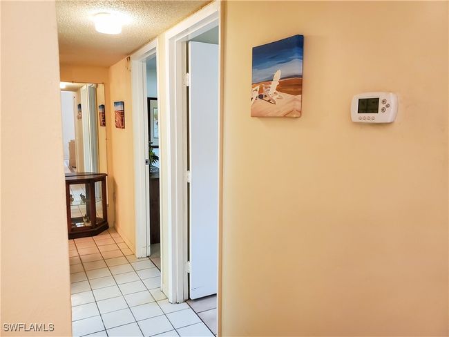 Hall with a textured ceiling and light tile patterned floors | Image 13