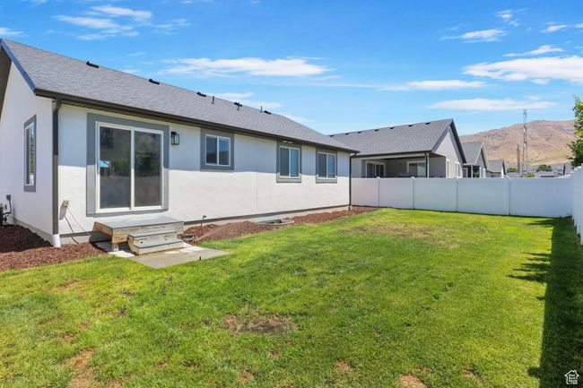 Rear view of house with a mountain view, stucco siding, and roof with shingles | Image 24