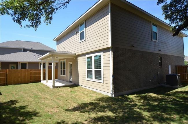 Rear view of house featuring brick siding, a fenced backyard, and a patio | Image 24