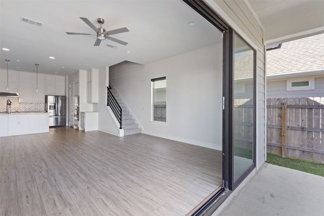 Unfurnished living room with ceiling fan, wood finished floors, stairway, and recessed lighting | Image 36