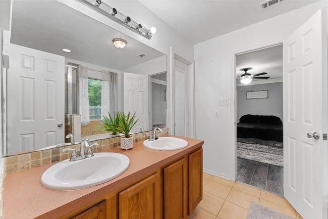 Full bath with double vanity, tile patterned floors, ensuite bath, a ceiling fan, and tasteful backsplash | Image 17