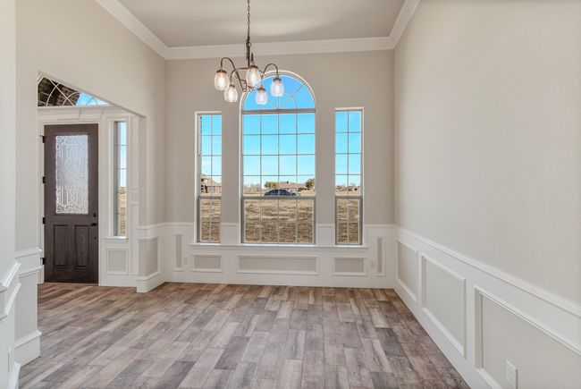 Foyer with a decorative wall, a chandelier, healthy amount of natural light, wood finished floors, and wainscoting | Image 12