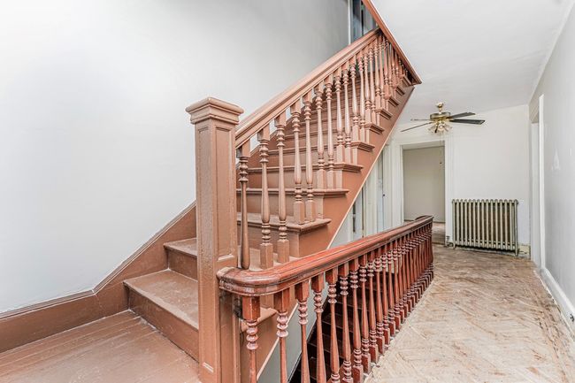 Stairs featuring radiator and ceiling fan | Image 15