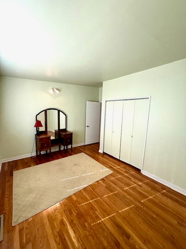 Bedroom with baseboards, a closet, and wood finished floors | Image 12