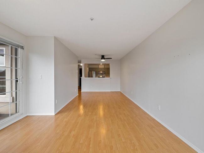 Unfurnished living room with baseboards, light wood-style flooring, a healthy amount of sunlight, and a ceiling fan | Image 10