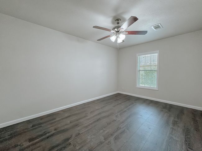 Spare room with dark wood-type flooring and a ceiling fan | Image 21