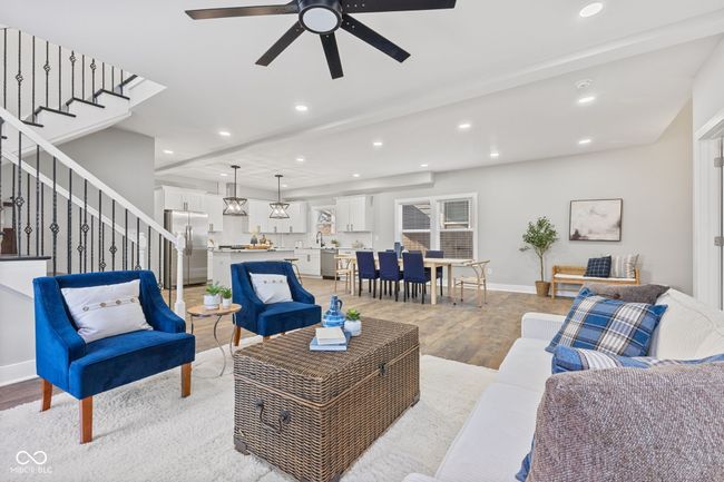 living area with recessed lighting, light wood finished floors, a ceiling fan, baseboards, and stairs | Image 5
