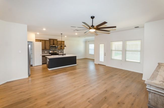 Living room featuring ceiling fan, recessed lighting, light wood finished floors, and baseboards | Image 8