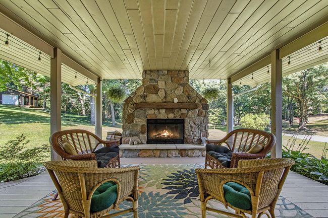 Covered porch with stone Fireplace. | Image 12