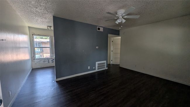 Spare room featuring dark wood finished floors, a textured ceiling, and ceiling fan | Image 4