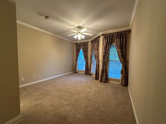 Carpeted spare room with crown molding and ceiling fan | Image 16
