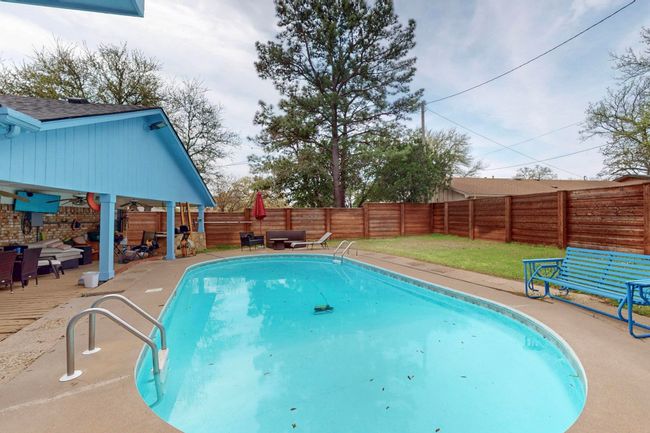 View of swimming pool featuring a fenced backyard, a fenced in pool, a patio, and a ceiling fan | Image 34