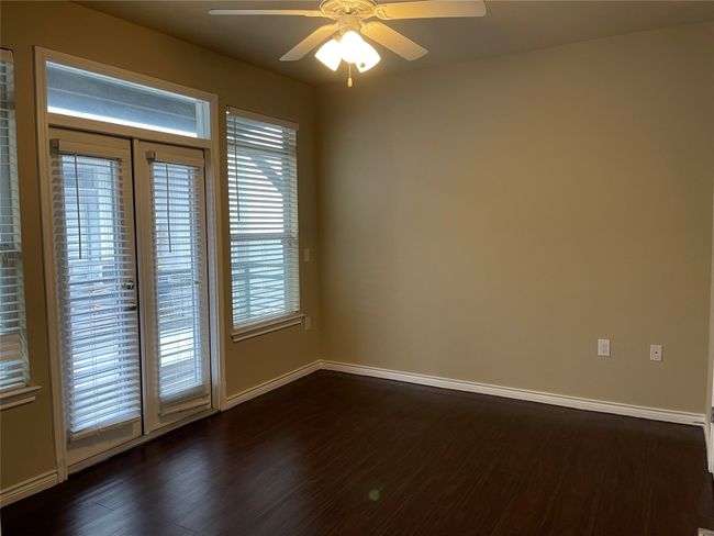 Empty room with ceiling fan and dark wood finished floors | Image 22