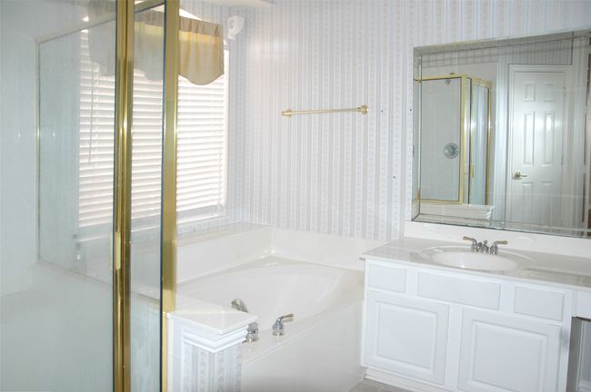 Bathroom featuring a bath, vanity, a shower stall, and wallpapered walls | Image 7