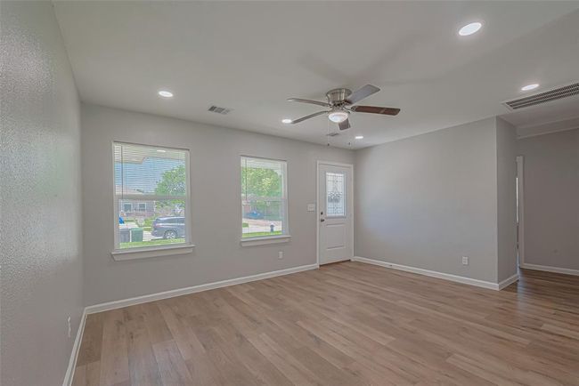 Step through the front door into a bright and welcoming living space, where large windows bring in natural light. | Image 6