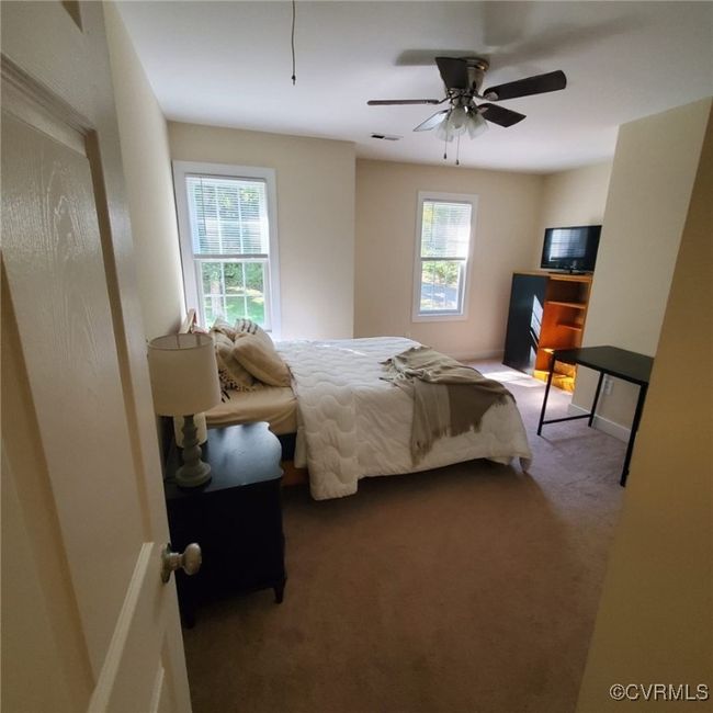 Bedroom with visible vents, baseboards, ceiling fan, and dark carpet | Image 40