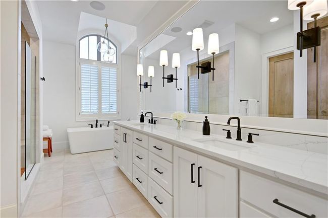 Full bath featuring a freestanding bath, tile patterned flooring, tiled shower, and a sink | Image 34