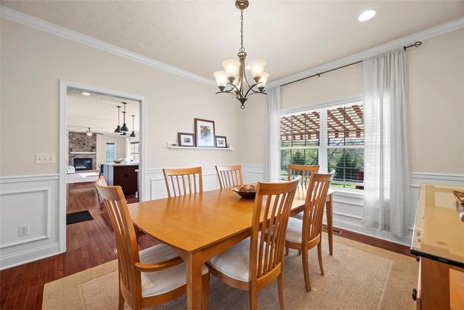Gather with friends and family in this spacious dining room adorned with crown molding and continued wainscoting. | Image 21