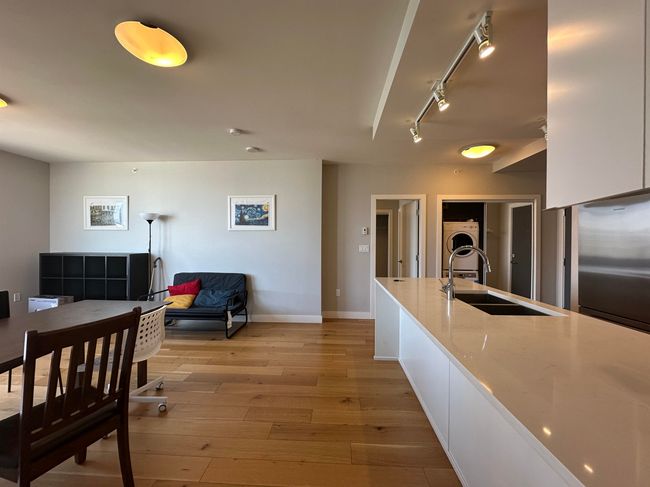 Kitchen with a sink, track lighting, light wood finished floors, freestanding refrigerator, and baseboards | Image 22