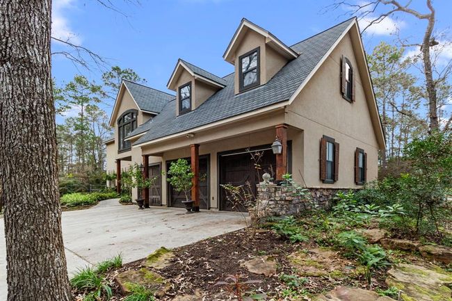 Cedar timber columns accent the exterior of the home much like the towering trees accent the surrounding landscape of the property. On the industrious 3-car garage, they support the overhang to provide respite from the weather. Three durable wood doors with ultra-quiet Marantec garage door openers diligently open and close without disturbing even the ambling deer. | Image 39
