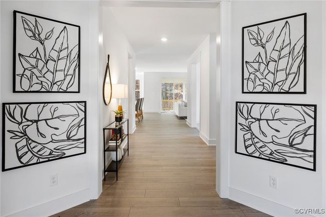 Bright hallway accented with modern artwork, leading to additional living spaces and private retreats. | Image 11
