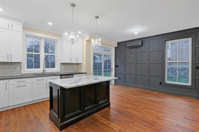 Kitchen is open to dining room featuring classic paneled wall. | Image 15