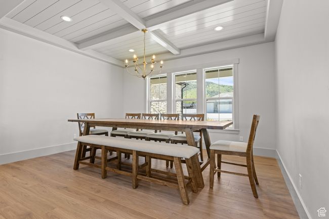 Dining area featuring a chandelier, light wood-type flooring, recessed lighting, and a wooden ceiling with exposed beams | Image 10
